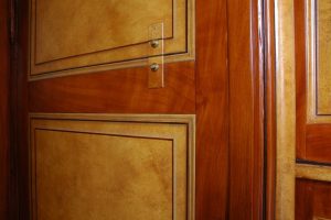 FAUX BOIS : Dans la bibliothèque d'un château classé, création et réalisation d'un décor de style empire, composé de Loupe d'orme, acajou sapelli et filets d'ébène, avec colonnes en faux marbre Vert-Vert et dorure à la feuille, fausses moulures et motifs en trompe l'oeil.