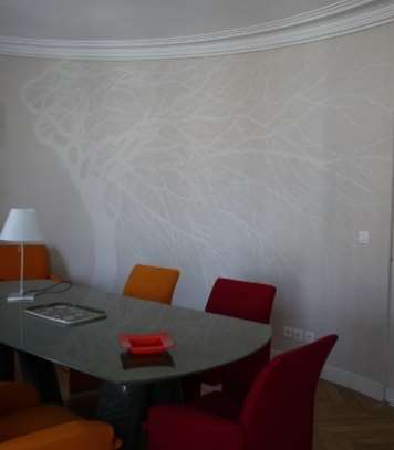 DECOR CONTEMPORAIN : dans la salle à manger d'un appartement parisien, panoramique de cerisier japonais en blanc cassé sur ton lin.