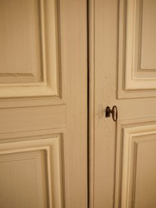 DECOR PEINT : Dans un salon d'un château classé monument historique français, décor peint des boiseries du XVIIIe siècle dans un style classique -détail des patines de 2 tons, gris et blanc cassé