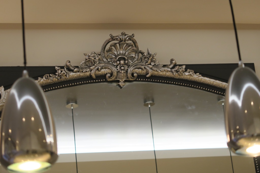 Sur un cadre de miroir d'un appartement parisien, décor de ton anthracite avec rehauts d'artgent.