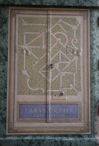 TROMPE L’ŒIL : détail du plan du labyrinthe de Versailles, avec fausses moulures ornementées, lettres peintes et décor végétal