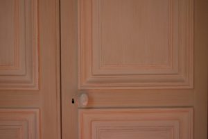 DECOR CLASSIQUE : détail de décor composé de patines spaltées et pastillées de 2 ton de gris, avec moulures et filets sur les panneaux de ton blanc cassé.