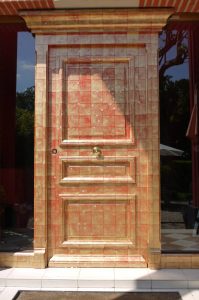 Dorure : imitation de feuilles d'or sur fond rouge sur une porte