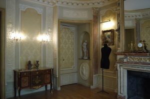 DECOR PEINT : Dans une chambre d’un appartement parisien en décor de style néoclassique XVIIIe siècle, avec patntes et filets dorés, faux marbres et dorures sur les pilastres et la cheminée