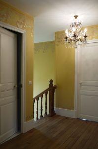 RESTITUTION : sur les parties hautes et basses des murs des escaliers et paliers d’un hôtel particulier de style Art Nouveau d’Ile de France, décor de frise végétale de tons rosé, corail, or et argent, avec un jeu de brillance sur mat.