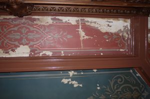 RESTAURATION : Dans les caissons au plafond d'une salle à manger de style néogothique, restauration des décors de motifs et filets taupe et dorés, sur fonds verts ou rouges. Détail du plafond avant restauration.