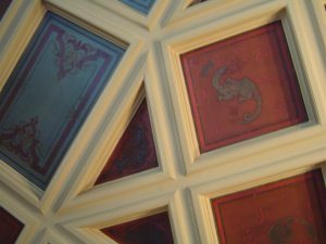 RESTAURATION : Dans une salle à manger de style néogothique d’un immeuble du XIXe siècle de style éclectique, restauration des décors des caissons du plafond très endommagé; décors de motifs et filets rouges et dorés, sur fonds verts ou rouges. Détail.