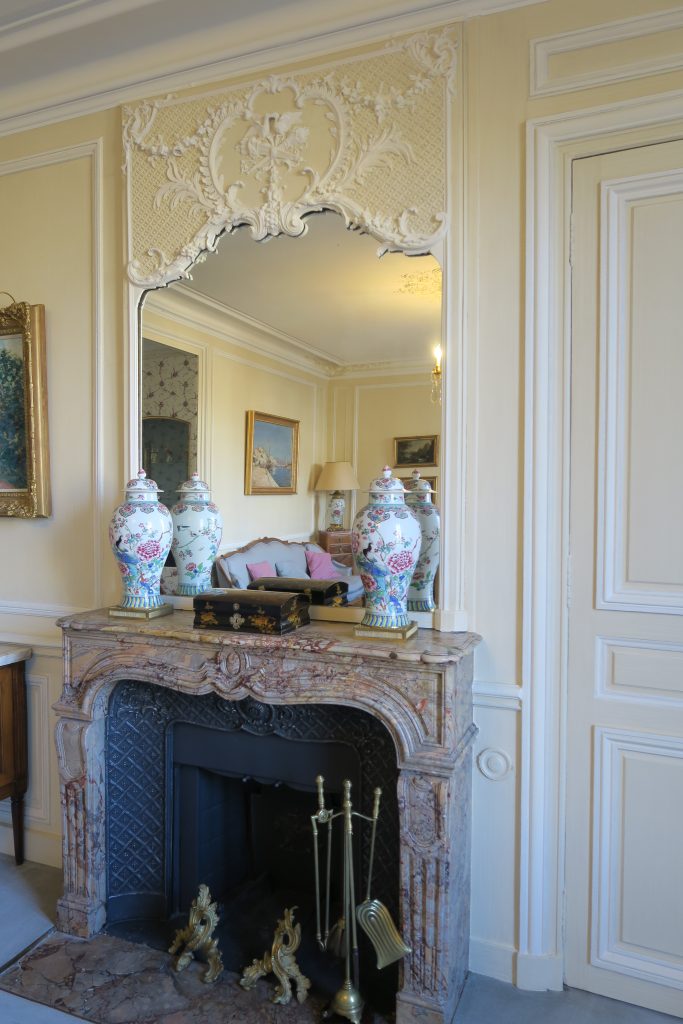 DECOR PEINT : dans un salon décor classique composé de patine spaltée ton paille, avec moulures blanc cassé et rehauts bleus; Sur le manteau de cheminée, imitation fonte, avec rehauts argentés sans ostentation.
