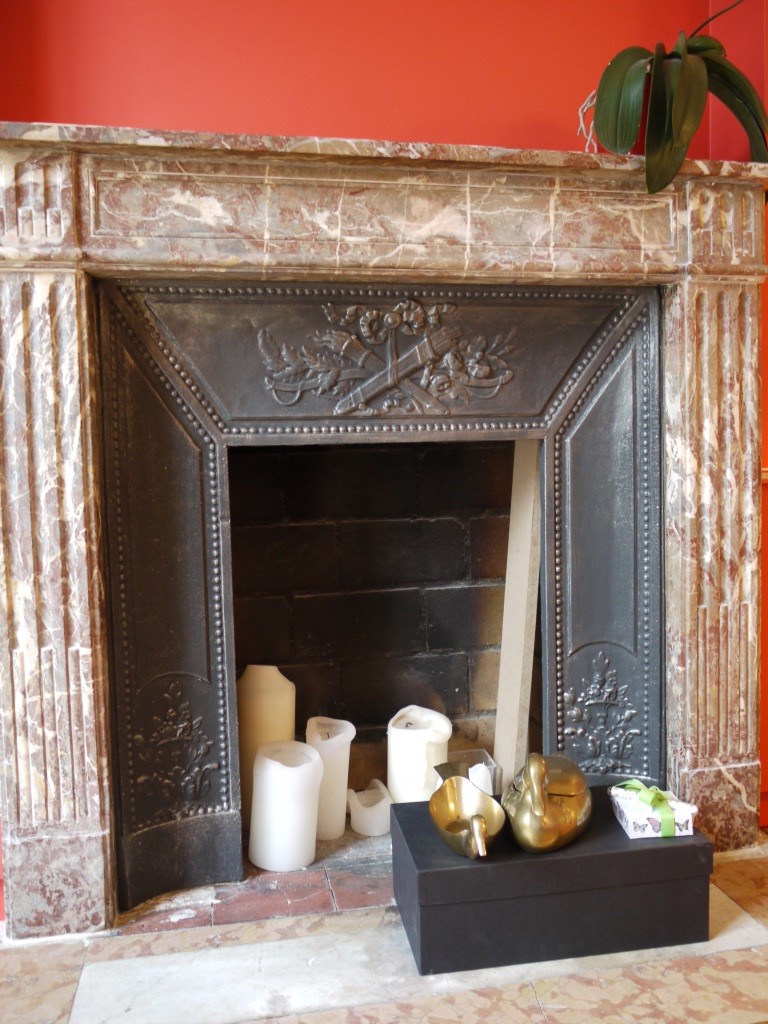 DECOR PEINT : Sur cette cheminée, mise en valeur du manteau ouvragé par l'imitation de plaques d'étain, une patine argent sur fond gris/noir.