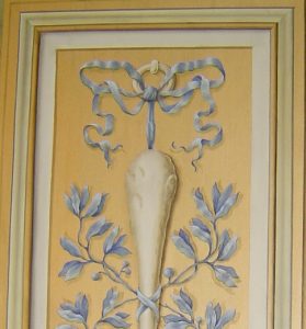 TROMPE L'OEIL : Copie d'un des éléments du décor de grotesque du XVIIe siècle au château de Vaux le Vicomte, avec motifs en grisaille et bleu peints sur fond doré et cadre en fausse moulure. Détail haut.