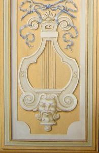 TROMPE L'OEIL : Copie d'un des éléments du décor de grotesque du XVIIe siècle au château de Vaux le Vicomte, avec motifs en grisaille et bleu peints sur fond doré et cadre en fausse moulure. Détail bas