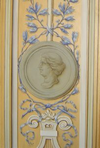 TROMPE L'OEIL : Copie d'un des éléments du décor de grotesque du XVIIe siècle au château de Vaux le Vicomte, avec motifs en grisaille et bleu peints sur fond doré et cadre en fausse moulure. Détail milieu.