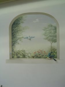 TROMPE L'OEIL : dans une véranda, décor peint d'une ouverture sur un jardin, au ciel bleu,, avec deux oiseaux.