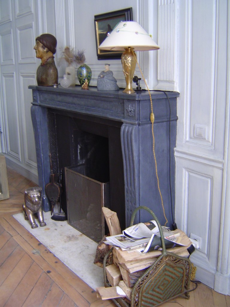 DECOR PEINT: Dans une chambre à coucher dont les belles boiseries ont été patinées de bleu doux, la cheminé a été patinée d'une imitation d'ardoise gris bleu.