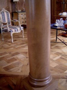 Faux bois : Dans un appartement d’un hôtel particulier, restitution sur des colonnes en staff, du chêne véritable des boiseries de style Régence. magnifiquement sculptées.