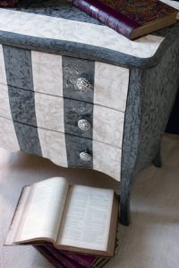 Meuble peint : décor de stucco pour cette commode, les boutons des tiroirs sont en coquille d'oeuf