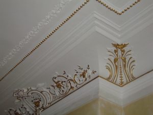 DECOR PEINT : réalisation, selon la demande, de décors de rehauts dorés sur certains des beaux motifs d'angle des corniches et des perles au plafond d'un appartement Haussmannien (détail)