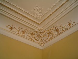 DECOR PEINT : réalisation, selon la demande, de décors de rehauts dorés sur certains des beaux motifs d'angle des corniches et des perles au plafond d'un appartement Haussmannien (détail)