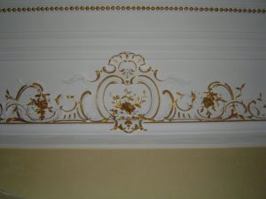 DECOR PEINT : réalisation, selon la demande, de décors de rehauts dorés sur certains des beaux motifs en cartouche des corniches et des perles au plafond d'un appartement Haussmannien (détail)