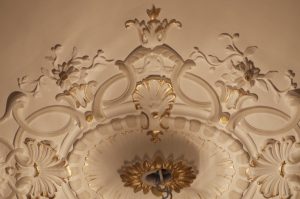 DECOR PEINT : réalisation, selon la demande, de décors de rehauts gris et dorés sur certains des beaux motifs de la rosace au plafond d'un appartement Haussmannien (détail)