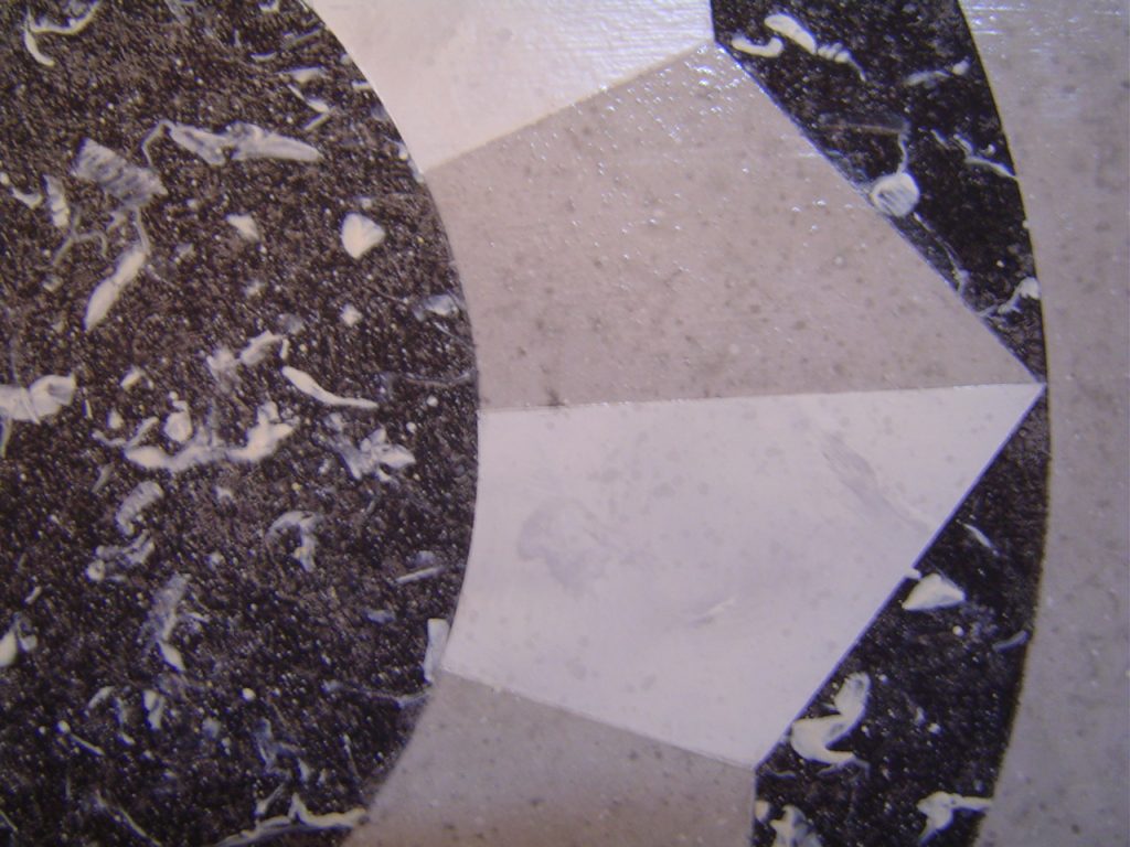 Sur un petit guéridon, imitation de marqueterie de faux marbres noirs, gris, blanc, de style Néoclassique,